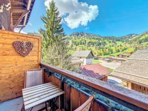 a wooden balcony with a bench and a heart ornament at Appartement 6 pers à La Clusaz, balcon et wifi - FR-1-818-103 in La Clusaz
