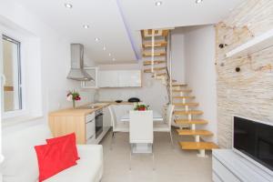a kitchen and a living room with a spiral staircase at Holiday Home Primabella in Primošten