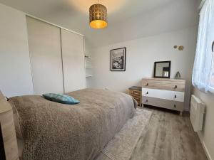 a bedroom with a bed with a blue pillow on it at Appartement cosy pour 4 personnes au cœur de la Forêt-Fouesnant - FR-1-481-179 in La Forêt-Fouesnant