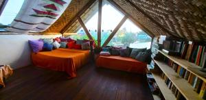 a room with two beds in a room with windows at Pousada Contos da Lua Vaga in Milho Verde