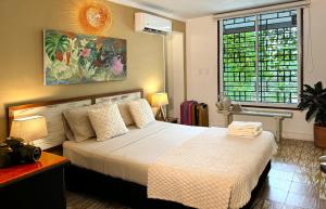 a bedroom with a bed and a large window at Cacao Hostel Santa Marta in Santa Marta