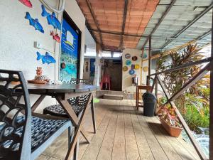 a dining room with a table and chairs on a porch at Sua Casa em Noronha - Conforto e Charme na Pousada da Iris in Fernando de Noronha