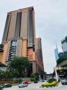 a tall building with cars driving on a city street at Max Suites At Barjaya Times Square Kl in Kuala Lumpur