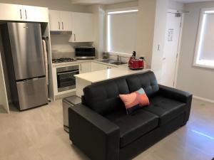 a living room with a black couch in a kitchen at LUX Jesmond in Jesmond