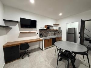 a kitchen with a desk and a table with a television at Departamento Colima 2 in Colima