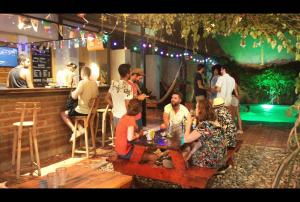 a group of people sitting at a table in a bar at Cacao Hostel Santa Marta in Santa Marta