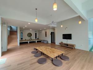 a large room with a wooden table and a tv at Sunya Home Raub Pahang Basement in Raub +10 photos