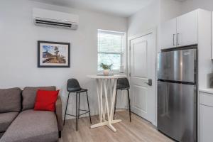 a living room with a couch and a table and a refrigerator at Courtyard Cottage- 15 Min Walk to Downtown in Saint Augustine