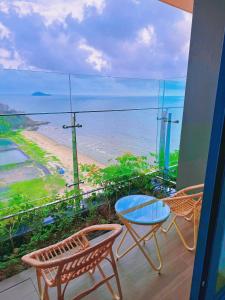 un balcon avec une table et des chaises et l'océan dans l'établissement Tòa nhà IBIZA, Khu nghỉ dưỡng Flamingo Hải Tiến, Hoàng Trường, Hoằng Hóa, Thanh hóa, à Gò Ba Quần