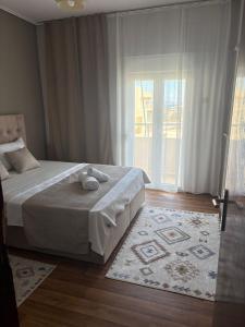 ein Schlafzimmer mit einem Bett und einem großen Fenster in der Unterkunft SMYRNA HOMES KALYOPi in Chios