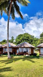 une maison avec un palmier devant dans l'établissement Lavana Dive & Nature Resort, à Unauna