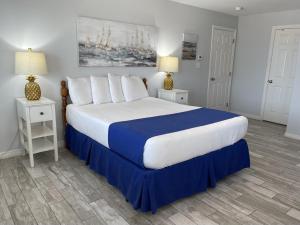 a bedroom with a large bed with blue and white sheets at Beachgate Condo Suites and Hotel 217 condo in Port Aransas