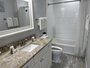 a bathroom with a sink and a toilet and a tub at Beachgate Condo Suites and Hotel 217 condo in Port Aransas