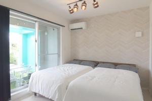 a bedroom with a white bed and a window at at60percent in Miyako-jima +27 photos