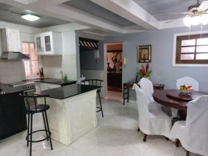 a kitchen and dining room with a table and chairs at Hilltop Inn in San Isidro
