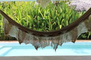 a hammock in a garden next to a pool at Sleepy Gypsea Villa Siargao - Diamond in Catagnan