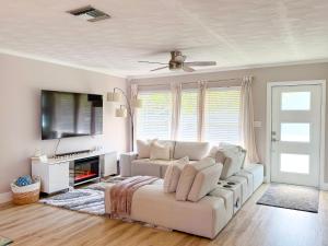 ein Wohnzimmer mit einem weißen Sofa und einem Fernseher in der Unterkunft Rockstar Hideaway Entire Home 2BR 2BA Office Space Guest Room & Outdoor Patio in Hollywood