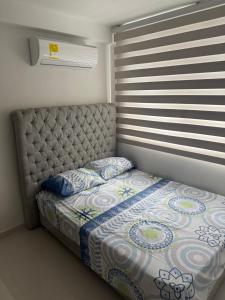 a bed with a headboard in a bedroom with a window at Apartamento norte de Barranquilla in Barranquilla