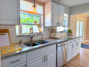 eine Küche mit weißen Schränken und einer Spüle in der Unterkunft Rockstar Hideaway Entire Home 2BR 2BA Office Space Guest Room & Outdoor Patio in Hollywood