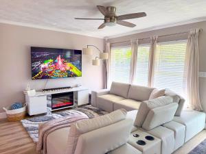 ein Wohnzimmer mit weißen Möbeln und einem Flachbild-TV in der Unterkunft Rockstar Hideaway Entire Home 2BR 2BA Office Space Guest Room & Outdoor Patio in Hollywood