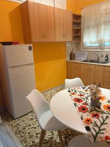 a kitchen with a white refrigerator and a table and chairs at SMYRNA HOMES CHiOS ERATO in Chios