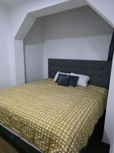 1 dormitorio con 1 cama con edredón amarillo en Casa sabina nuevo aeropuerto, en Lima