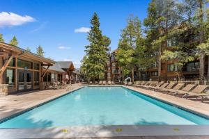 Una piscina con sillas y un edificio. en Mountainwood 201 by Summit County Mountain Retreats, en Breckenridge