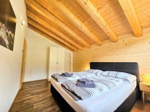 a large bed in a room with a wooden ceiling at Chalet Eigernordwand in Grindelwald
