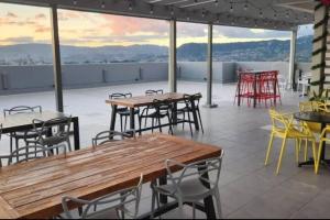 eine Terrasse mit Tischen und Stühlen auf einem Dach in der Unterkunft Apartamento con piscina in Tegucigalpa