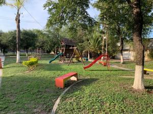 a park with a playground with slides and a tree at Un hogar lejos de Casa in Monterrey