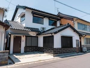 una casa bianca con il tetto nero di 出雲和結庵 a Taisha