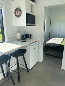 a kitchen with a table and two chairs and a bed at Boutique Tiny House Stargazing & Rural Views in Parore