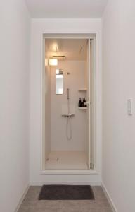 a bathroom with a shower with a glass door at Pension Sora in Nachikatsuura