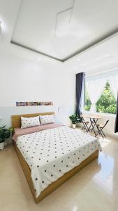 a bedroom with a large bed in a white room at Phòng homestay gần biển, TTTP - 1988 homestay in Vung Tau