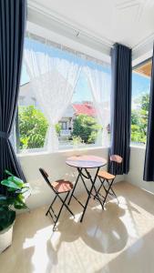 a dining room with a table and chairs in front of a window at Phòng homestay gần biển, TTTP - 1988 homestay in Vung Tau