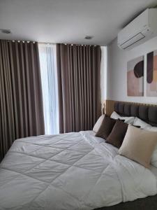 a bedroom with a large white bed in front of a window at Condominium Unit at One Pontefino Tower in Batangas City +7 photos