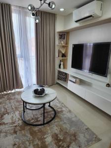 a living room with a table and a flat screen tv at Condominium Unit at One Pontefino Tower in Batangas City
