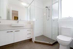 ein weißes Badezimmer mit Dusche und Toilette in der Unterkunft EAST3 - Coastal Hideaway in Mosman Park + 4 Fotos