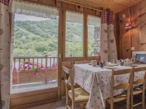 阿尔克河畔博讷瓦勒Chalet le Névé的带桌子和大窗户的餐厅