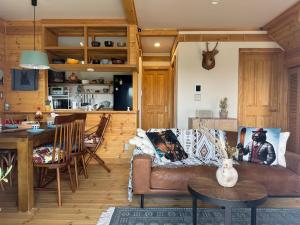 a living room with a couch and a table at Best Day Ever Furano Lodges in Furano +59 photos