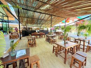 a restaurant with wooden tables and wooden chairs at Atlas Central in Pai