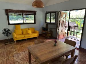 sala de estar con mesa y sofá amarillo en Peace and harmony, en Ban Tham