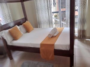 a bed with a wooden frame with two towels on it at Mtwapa Homes M Luxury Apartments in Mombasa