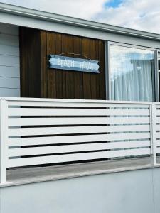 a house with a white fence and a sign on it at Peaceful Oasis near the Beach and Mount Mainstreet Shopping Centre in Mount Maunganui