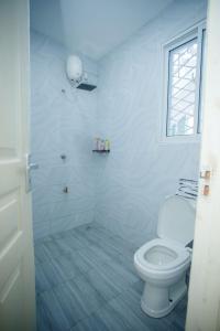 ein weißes Badezimmer mit Toilette und Dusche in der Unterkunft Clarah's paradise in Mombasa