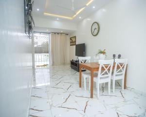 ein Esszimmer mit Tisch und Stühlen und einer Uhr in der Unterkunft Clarah's paradise in Mombasa + 4 Fotos