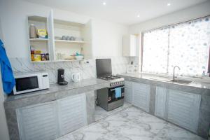 a kitchen with a sink and a stove top oven at Clarah's paradise in Mombasa
