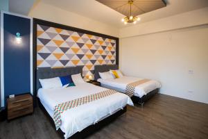 a hotel room with two beds and a wall at Salmon B&B in Hualien City