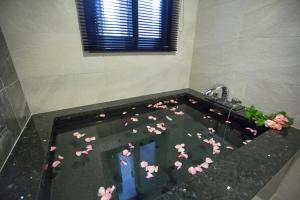a bathroom with a bath tub filled with pink flowers at Salmon B&B in Hualien City