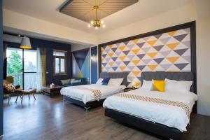 a hotel room with two beds and a living area at Salmon B&B in Hualien City